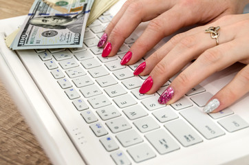 Hands of a woman on a laptop keyboard