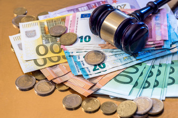 hammer with many euro bills and coin
