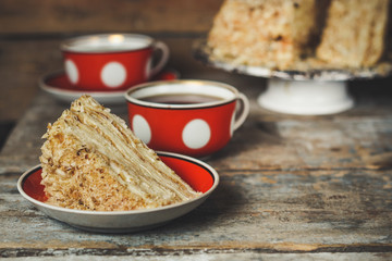 cake - Napoleon (cake with white cream is layered) and photos on a wooden table