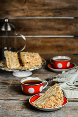 cake - Napoleon (cake with white cream is layered) and photos on a wooden table