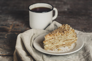 cake - Napoleon (cake with white cream is layered) and photos on a wooden table