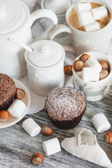 Cups with cacao and marshmallow, cupcakes and different decorations