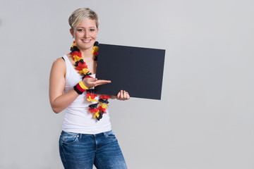 Smiling german girl holding black scoreboard