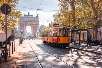 Fototapete Milaan Berühmte Vintage Straßenbahn im Zentrum der Altstadt von Mailand am sonnigen Tag, Lombardia, Italien. Friedensbogen oder Arco della Pace im Hintergrund.