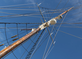 Fototapeta premium Sailboat Mast and ropes with cloudy blue sky in the background