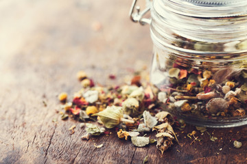 Mountain herbal tea on a wooden old table in a glass jar - obrazy, fototapety, plakaty