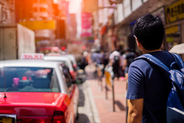 Young asian traveler waiting taxi for transportation at Hong Kong city