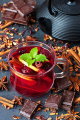 Red Hot Hibiscus tea in glass mug on  dark  table among  dry tea