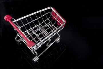 A trolley on black background. Shopping concept.