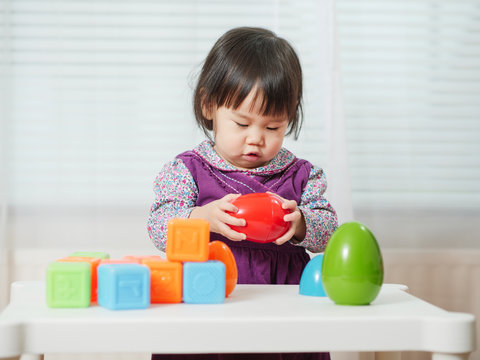 baby girl playing geometry blocks at home