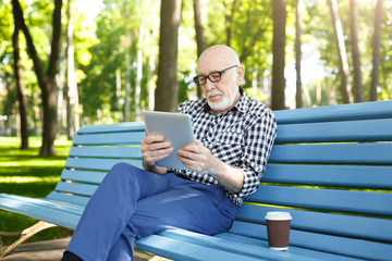 Fototapeta premium Senior man in casual with digital tablet outdoors