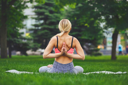 Young woman outdoors, Reverse Prayer Pose
