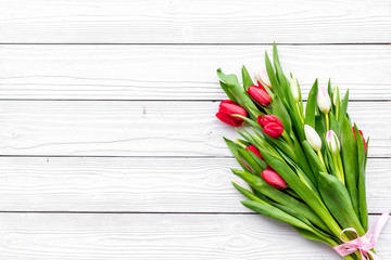 First spring flowers. Bouqet of delicate tulips on white wooden background top view copy space