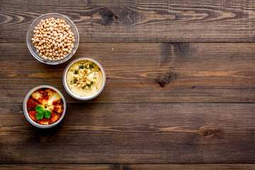 Cook chickpeas. Make hummus. Bowls with grains and ready meal on dark wooden background top view copy space