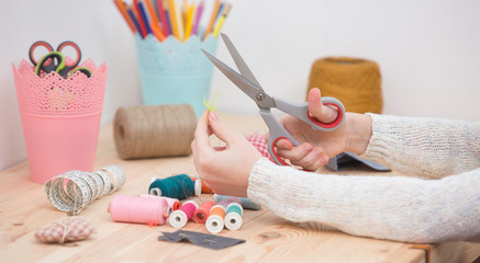 girl sews doll clothes, Child sewing  - obrazy, fototapety, plakaty