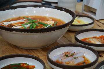 Close up Korea kimji soup with soft tofu and enoki mushroom. Korea cuisine, hot soup serve with pickle vegetable side dish.
