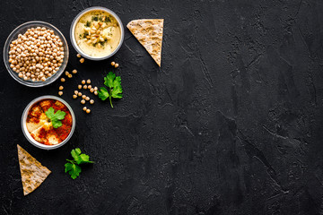 Cook chickpeas. Make hummus. Bowls with grains and ready meal near spices on black background top view copy space