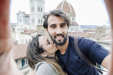 Loving couple taking a selfie in front of the church Santa Maria del Fiore, Florence Cathedral