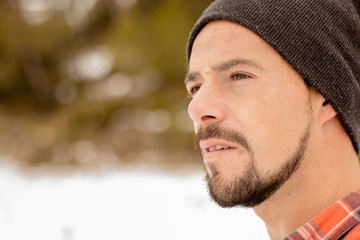 Fototapeta premium Pensive man with beard,plaid t-shirt,hat and casual clothes. A young and carefree lifestyle.