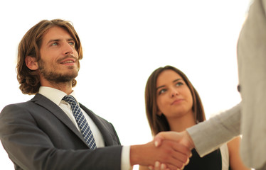 Businesspeople  shaking hands against room with large window loo