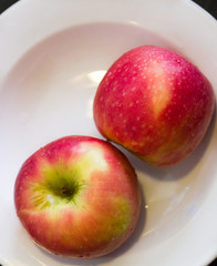 A pair of pink apples on a white plate