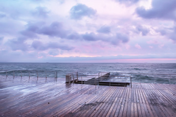 Very early morning at sea. a wooden desert pier. Black Sea. Soft soft tones and focus. A gentle sea.
