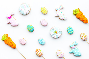 Easter background. Cookies in shape of Easter eggs and Easter bunny. White background top view pattern