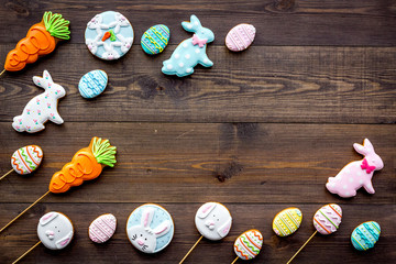 Easter background. Cookies in shape of easter bunny and easter eggs. Dark wooden background top view copy space