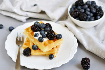Homemade Belgian Waffles with Cream  Sauce Berries Gray Background Table Kitchen Towel White Plate  