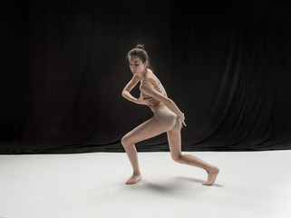 Fototapeta na wymiar Young teen dancer on white floor background.