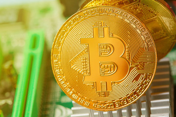 Golden Bitcoin Cryptocurrency on computer circuit board. Macro shot