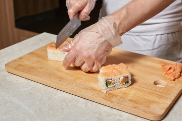Chef making sushi. Preparing rolls with salmon