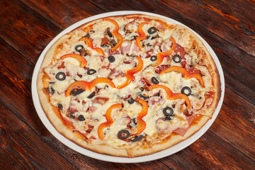 Fresh baked pizza on wooden background