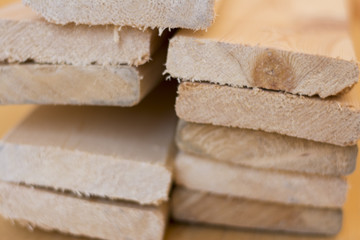 Wooden boards lie on top of each other in a pile