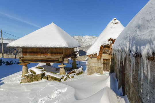 The snow covers the pallozas and horreos, old typical constructions of the Galician mountain, in Piornedo, Lugo, Galicia