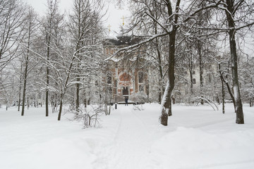 Fototapeta premium The Orthodox Church, the Moscow State United Historical and Architectural and Natural Landscape Museum-Reserve, Izmaylovo Estate, a gloomy winter day, white snow, bare trees.