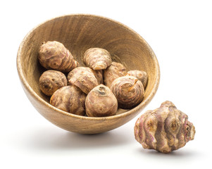 Jerusalem artichoke tubers in a wooden bowl isolated on white background sweet crisp topinambur.