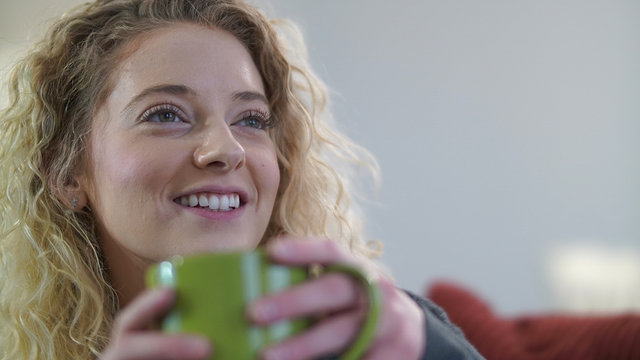 Attractive blonde woman sitting with coffee cup engaged in conversation