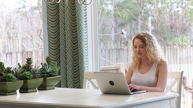 Attractive Blonde Woman working on laptop in a modern home interior