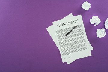 Naklejka premium top view of business contract with pen on purple surface