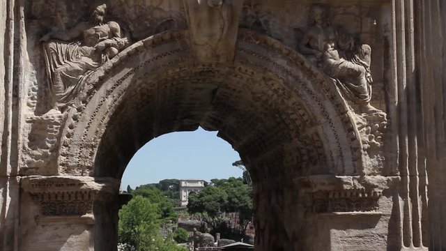 Roma, Italia. Foro Romano. Particolare dell'Arco di Settimio Severo con Arco di Tito sullo sfondo