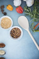 Chilli seeds, garlic flakes, rosemary, garlic and chilli peppers on a blue background 