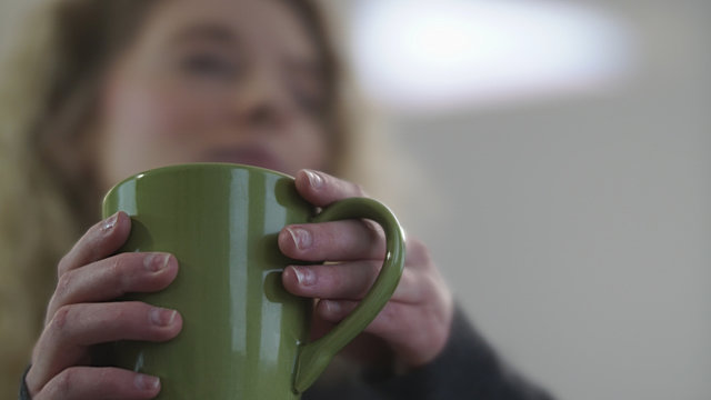 Female hands holding green coffee cup