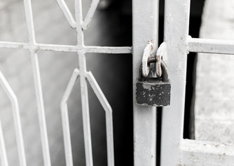 Closed old folding lock on metal latticed doors.