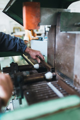 Manual worker cutting aluminum and PVC profiles. Manufacturing jobs. Selective focus. Factory for aluminum and PVC windows and doors production.