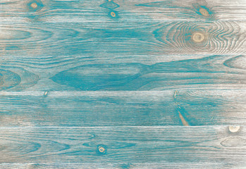 Flat wood background with teal sanded paint over wood grain and knots. Neutral brown and gray...