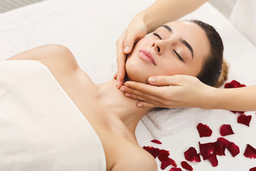 Obraz na płótnie Canvas Woman getting professional facial massage at beauty salon