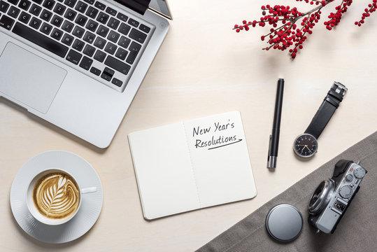 New year's resolution written on notepad in office as flatlay