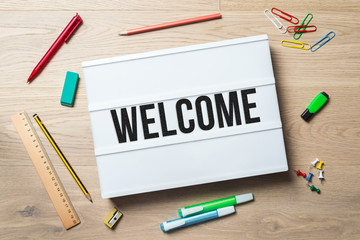 Welcome written on lightbox in office as flatlay