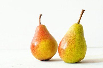 Two ripe red yellow pear fruits on white background